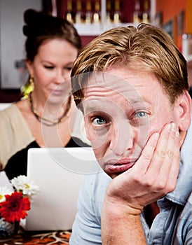 Bored man with woman on laptop computer