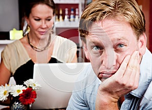 Bored man with woman on laptop computer