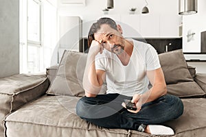 Bored mature man sitting on a sofa