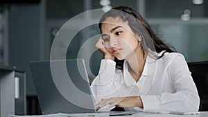 Bored sad lazy young indian woman manager sitting in office unmotivated uninterested in boring laptop work overworked