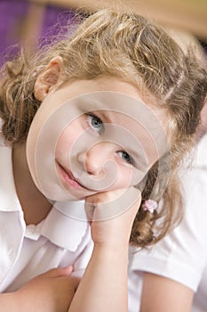 Bored schoolgirl sitting in primary class