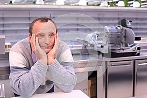 Bored seller in shop with empty shelves