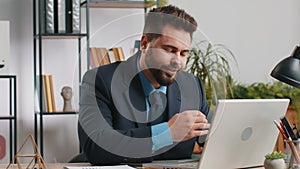 Bored sleepy business man worker working on laptop computer, yawning, falling asleep at home office