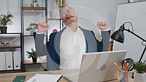 Bored sleepy business man worker working on laptop computer, yawning, falling asleep at office