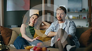 Bored spouses watching movie feeling disinterested at home. Man woman laughing photo