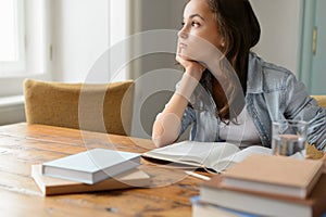 Bored student girl sitting home looking away