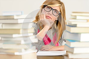Bored student girl between stack of books