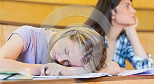 Bored student listening while classmate sleeping