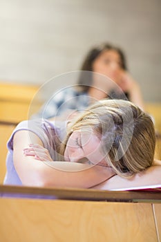 Bored student listening while classmate sleeping
