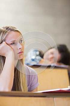 Bored student listening while classmate sleeping