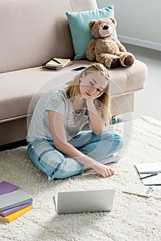 bored teen student girl working with laptop while sitting