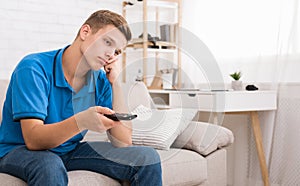 Bored teen switching channels with remote controller