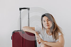 Bored and tired face woman in her private loungewear and baggage isolated on white. photo