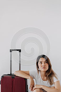 Bored and tired face woman in her private loungewear and baggage isolated on white. photo