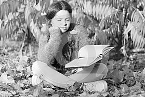 Bored and tired. Little child enjoy learning at backyard or park. Kid study with book. Self education concept. Child