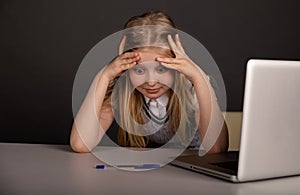 Bored and tired little girl sitting infront of the computer. Feeling sick concept.