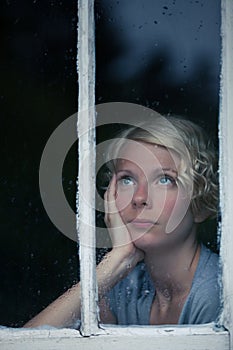 Bored Woman Looking at the Rainy Weather By the Window