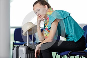 bored woman with suitcase in airport waiting