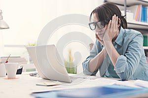 Bored woman working with her laptop