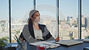 Bored worker tapping desk in modern office. Beautiful businesswoman thinking