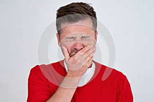 bored yawning tired caucasian man covering mouth with hand.