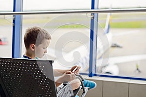 Bored 7 years old boy child waiting for his plane