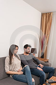 Bored young couple sitting on couch. photo