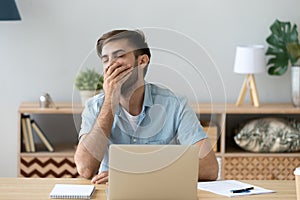 Bored young man sitting at the desk