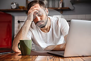 Bored young man using laptop computer