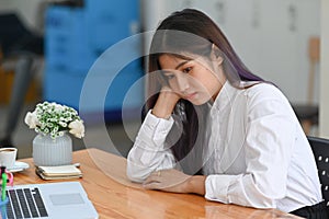 Bored woman office worker sitting at her desk in front of computer laptop.