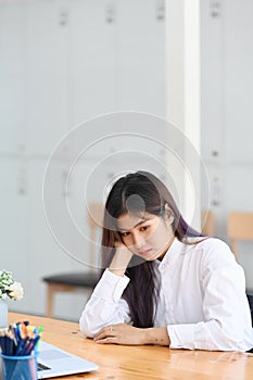Bored woman office worker sitting at her workplace.
