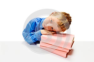 Boring boy of elementary class sitting at desk put his head on textbooks. Child study and learn for preschool. Online