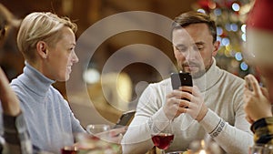 Boring Christmas dinner with smartphones, close up on couple