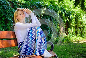 Boring literature. Woman tired face blonde take break relaxing in garden reading book. Lady student read boring