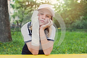 Boring teenage girl young sportswoman with arm injury outdoors