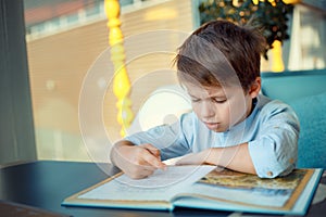 Boring and tired little boy reading book