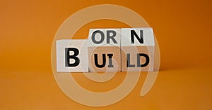 Born and Build symbol. Turned wooden cubes with words Build to Born. Beautiful orange background. Business and Born and Build