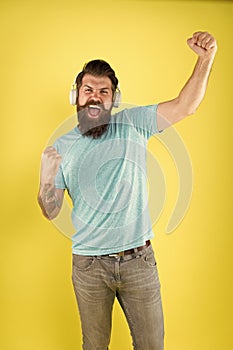 Born to win. Happy winner listen to music. Bearded man make winner gesture. Emotional hipster shout loud yellow