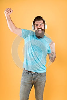 Born to win. Happy winner listen to music. Bearded man make winner gesture. Emotional hipster shout loud yellow