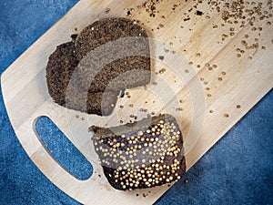 Borodino bread. Flour product. Bread with spices on kitchen board on black background