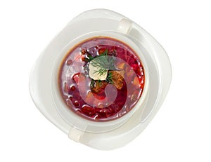 Borsch in white plate isolated on white. Beetroot soup closeup.