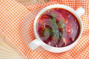 Borsch in white plate isolated on white. Red traditional beetroot soup.