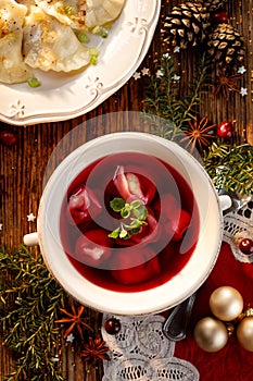 Borscht, beetroot soup with small dumplings with mushroom stuffing in a ceramic bowl. Traditional Christmas eve dish in Poland.
