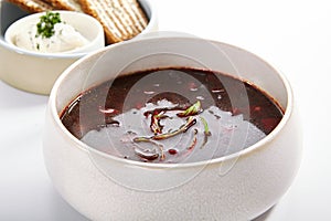 Borscht in bowl with roasted toasts and sour cream