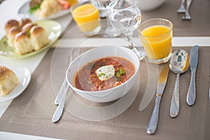 Borscht, Red Soup Made of Beetroot and Vegetables and Sour Cream Served with Garlic Rolls