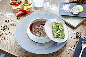 Borscht soup. Black Angus beef, beetroot, sour cream, toasted bread with smalec in a bowl. Delicious healthy food