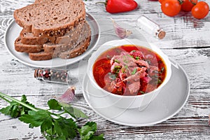 Borscht soup with meat in a white bowl