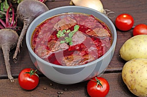 Borscht soup with vegetables and meat on a wooden table