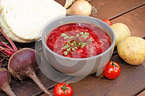 Borscht soup with vegetables and meat on a wooden table