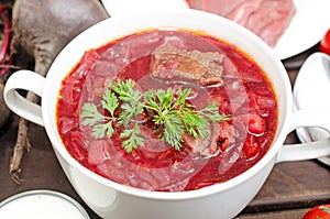 Borscht soup with vegetables and meat on a wooden table